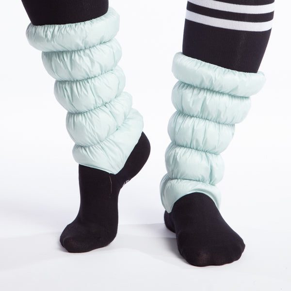 Hikas Gaiter in Alpine Mist front view with left foot flat on the ground and right foot on ball of the foot with heel raised approximately two and a half inches. 